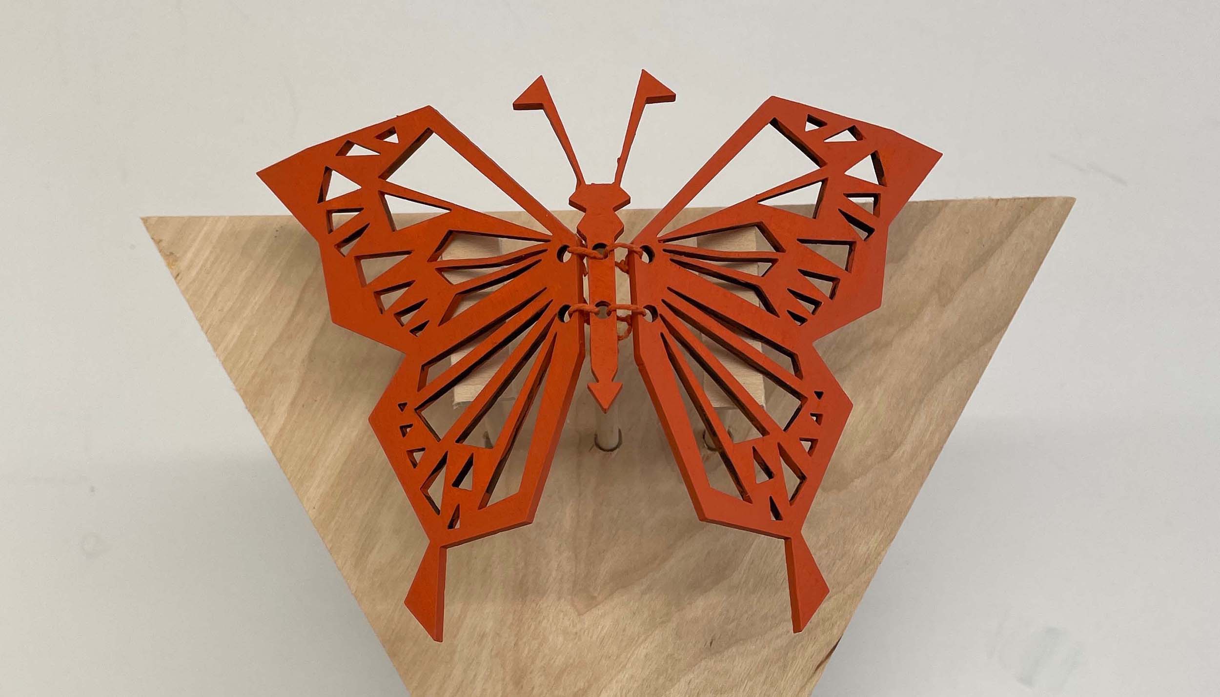 an image of an orange butterfly automata made from wood and acrylic